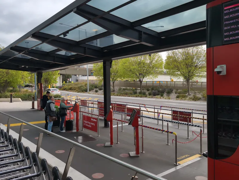 ターミナル4のSkyBus乗り場。赤い自動券売端末で買ってから、柵に沿って並ぶ