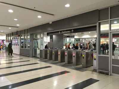 駅の改札。緑の矢印が通れるゲート、赤い×は逆向き。天板の読み取り機にタップして入る