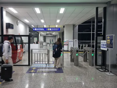 マンガライ駅の乗換口。「Loket KA Bandara（きっぷ売り場）」「Masuk KA Bandara（入口）」の案内
