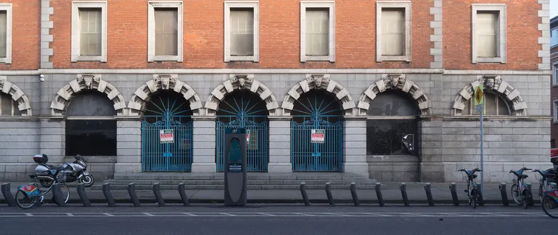 dublinbikesのステーション。中央に立つ柱が端末で、日券はここかアプリで買う。歩道の縁に沿って自転車を差すスタンドが並ぶ
