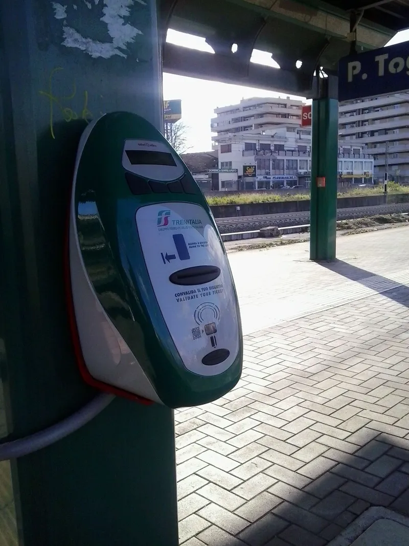 ホームの刻印機。「CONVALIDA IL TUO BIGLIETTO / VALIDATE YOUR TICKET」と書かれた緑のTrenitalia機に券を通す