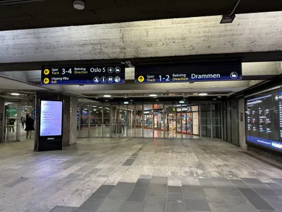 地下駅の案内は方向表示。「Spor 3-4＝Oslo S方面」「Spor 1-2＝Drammen方面」と、番線と行き先方向で示される