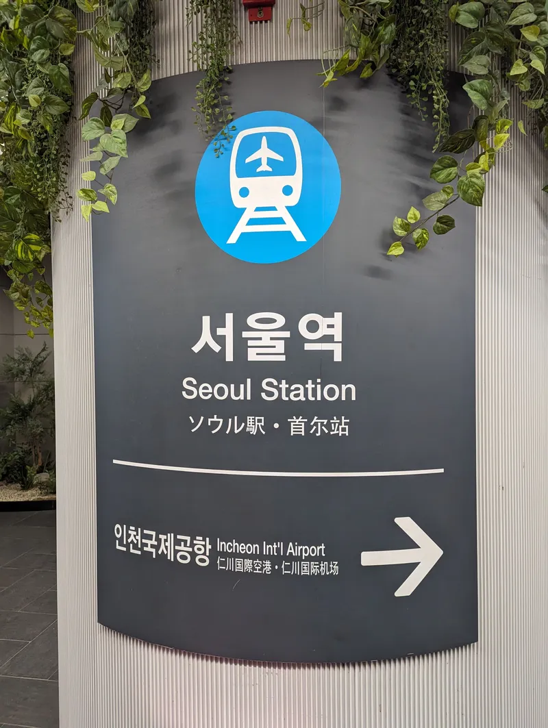 ソウル駅の空港鉄道（AREX）の案内。駅名は韓・英・日・中の4言語で、その下に「仁川国際空港→」の矢印が入る。