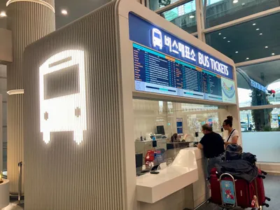 仁川空港第1ターミナルのバス発券窓口。「버스매표소 / BUS TICKETS」の看板の下に、系統と時刻の一覧が出ている。