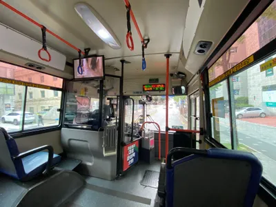 車内前方。天井のLEDが「하차시 태그안내／필수!!」＝降車時のタグは必須、と流れ続けている。運転席脇の箱が運賃箱。