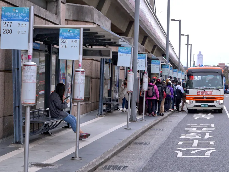 剣潭駅のバス停。頭上の板に系統番号と「往◯◯」の行き先、円筒のポールに路線図