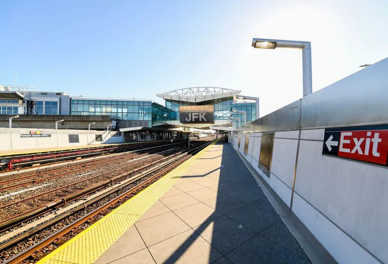 地下鉄A線ハワードビーチ–JFK駅のホーム。線路をまたぐガラスの改札階を上がり、その先でAirTrainへ乗り換える